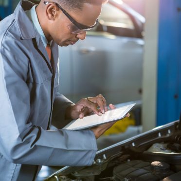 Mechanic using digital tablet at repair garage